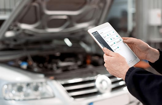 Een monteur in de werkplaats met een serviceplatform op een tablet